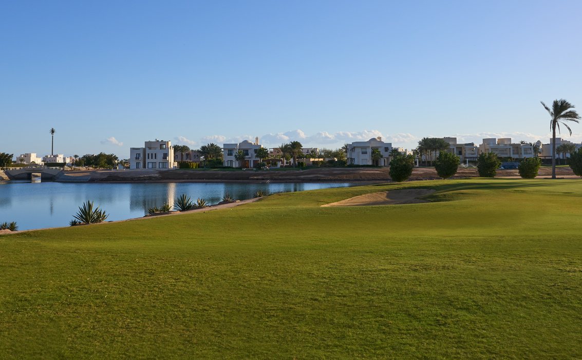 Grün auf dem Ancient Sands Golf Course in El Gouna, davor ein See