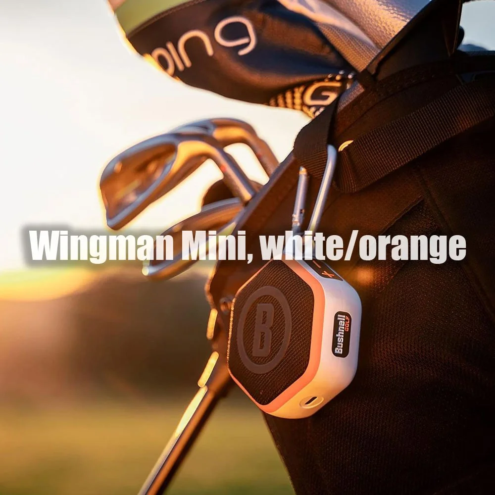 Bushnell Wingman Mini in weiss/orange, mit Karabiner an einem Golfbag im Abendlicht — der kompakte Lautsprecher für Deine Runde